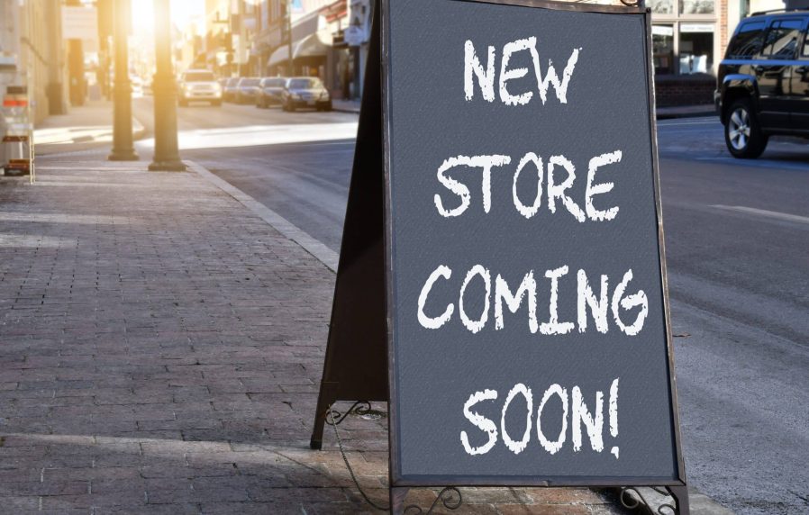 chalkboard-sign-on-sidewalk-proclaiming-new-store-2023-11-27-05-16-18-utc